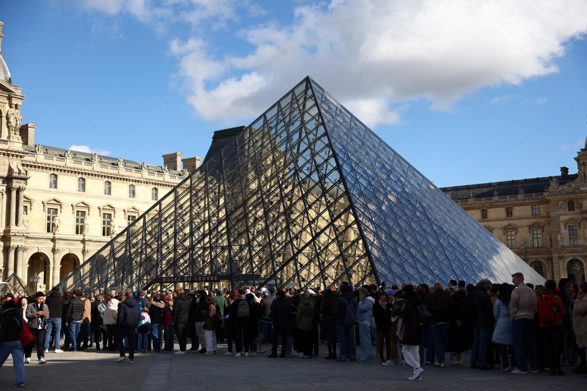 People stand outside the Louvre Museum, after French police arrested suspects in the Louvre heist case, in Paris, France October 26, 2025. REUTERS/Abdul Saboor