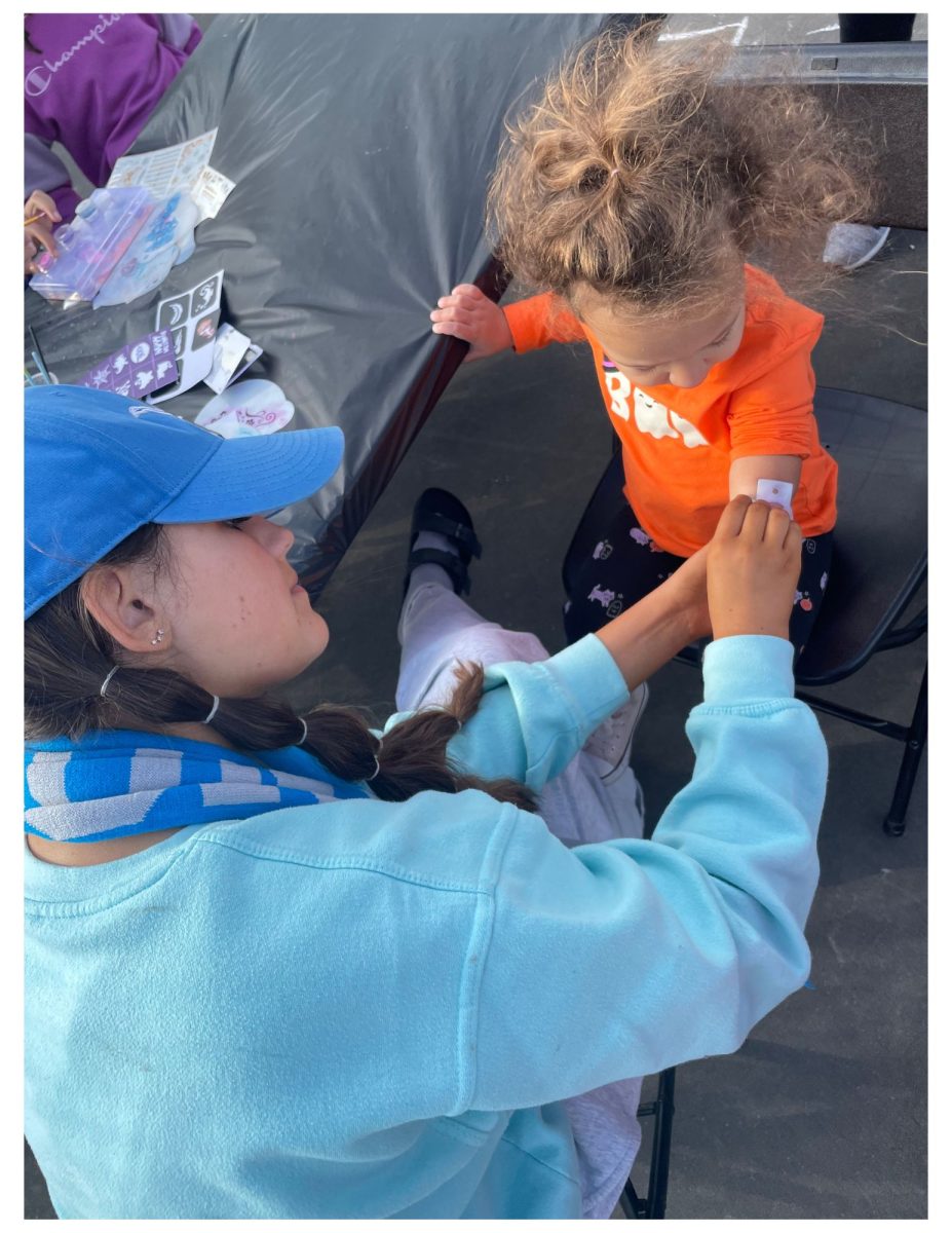 Villerot (2) with LHS Leadership student getting a mermaid scale tattoo