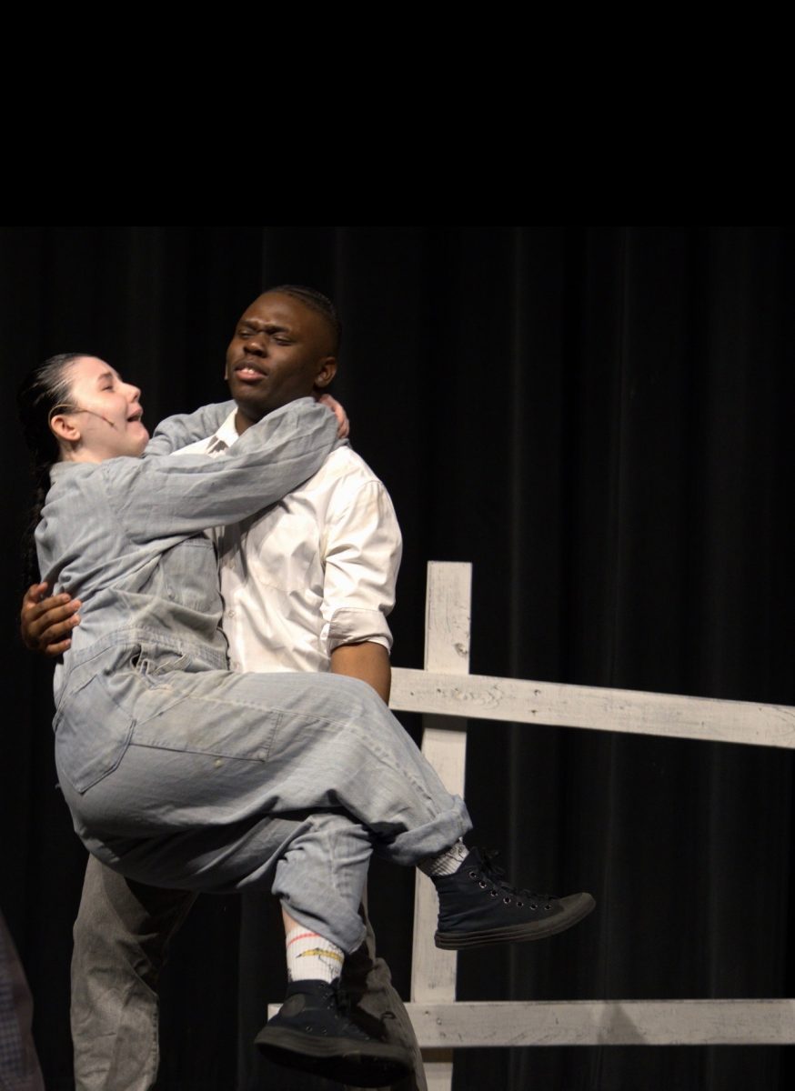 Brianna Poe being carried by Jordan Aaron in The Wizard of Oz